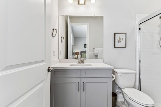 bathroom featuring a shower stall, toilet, and vanity