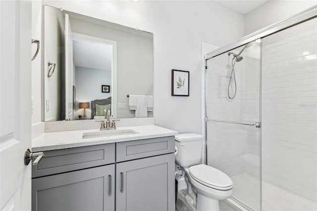 bathroom featuring vanity, toilet, a shower stall, and ensuite bathroom