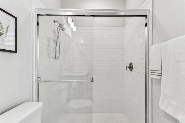 full bathroom with a stall shower and toilet