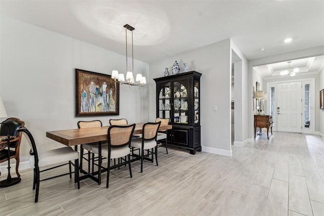 dining room featuring a chandelier, wood finish floors, and baseboards