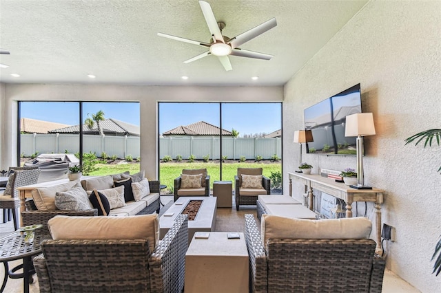 sunroom / solarium featuring a healthy amount of sunlight and ceiling fan