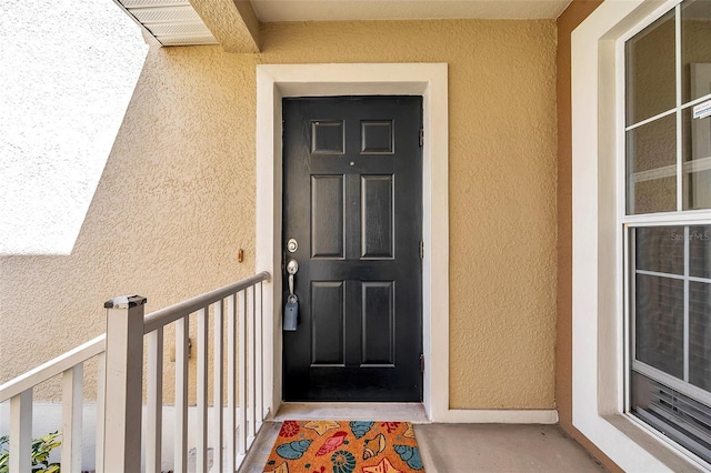 view of exterior entry featuring stucco siding