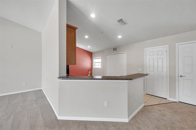 kitchen with visible vents, light carpet, and dark countertops