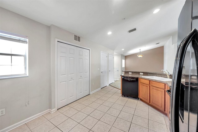 kitchen with visible vents, brown cabinets, light tile patterned flooring, black appliances, and a sink