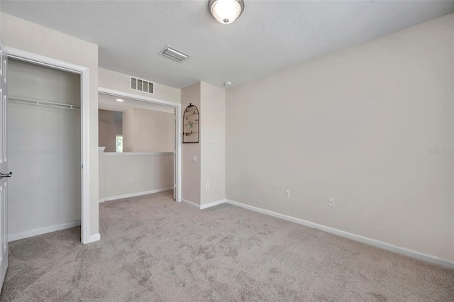 unfurnished bedroom featuring a closet, visible vents, baseboards, and carpet floors