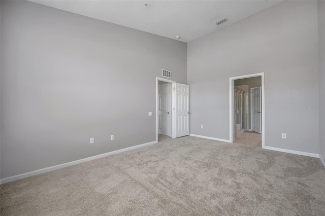 unfurnished bedroom featuring light carpet, visible vents, and baseboards