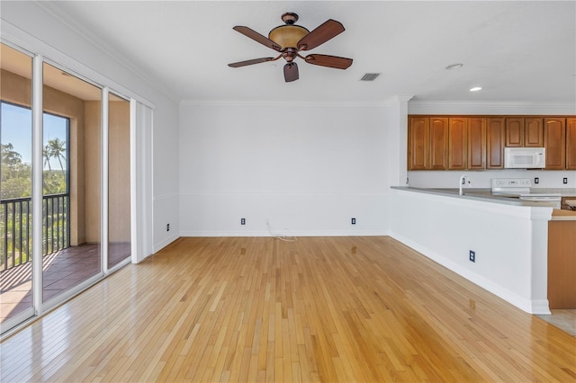 unfurnished living room with baseboards, visible vents, ceiling fan, light wood-style floors, and crown molding