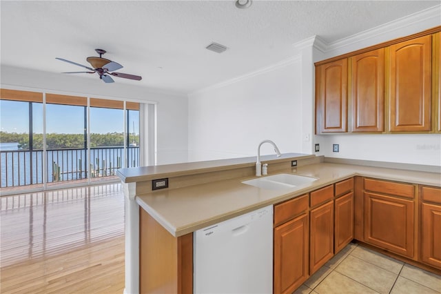 kitchen with visible vents, ornamental molding, white dishwasher, a ceiling fan, and a sink