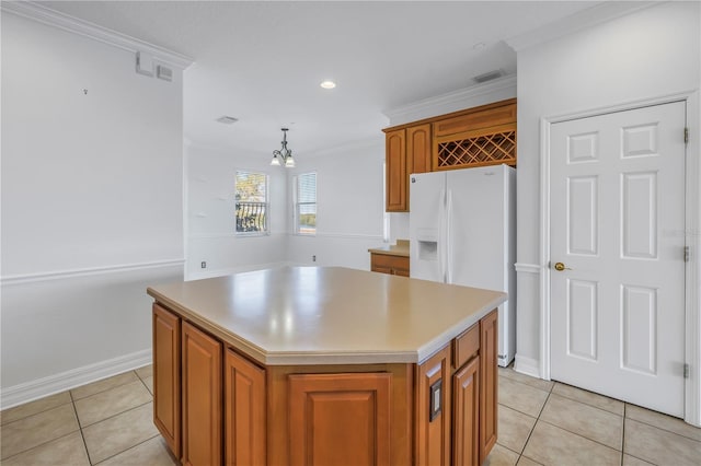 kitchen with ornamental molding, a kitchen island, white refrigerator with ice dispenser, brown cabinetry, and light tile patterned floors