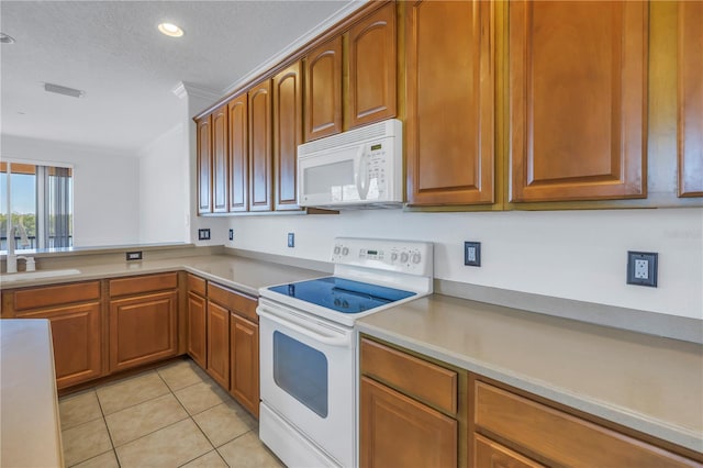 kitchen with white appliances, light tile patterned floors, visible vents, ornamental molding, and a sink