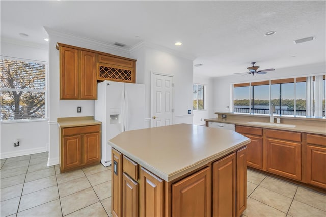 kitchen with a sink, a kitchen island, white appliances, light tile patterned floors, and ceiling fan