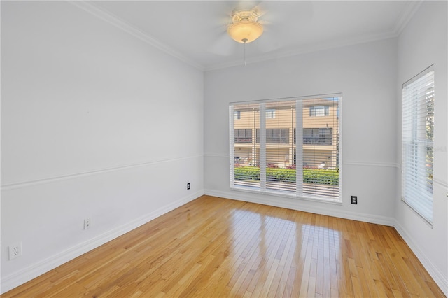 spare room with ceiling fan, light wood-style flooring, baseboards, and ornamental molding