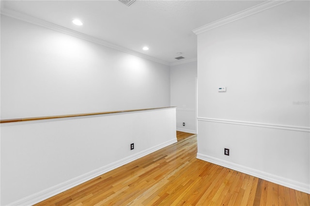 unfurnished room featuring recessed lighting, baseboards, light wood-type flooring, and ornamental molding