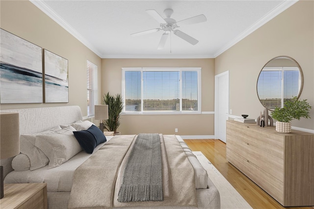 bedroom featuring ceiling fan, multiple windows, light wood-type flooring, and ornamental molding