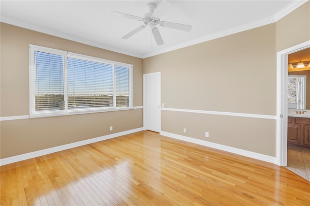 spare room featuring light wood-type flooring, baseboards, and ornamental molding