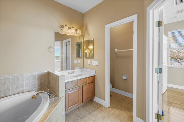 full bath featuring tile patterned flooring, visible vents, baseboards, a bath, and vanity