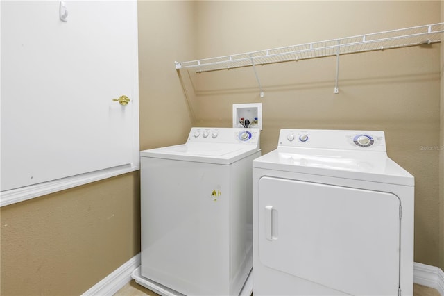 clothes washing area featuring washer and dryer, laundry area, and baseboards