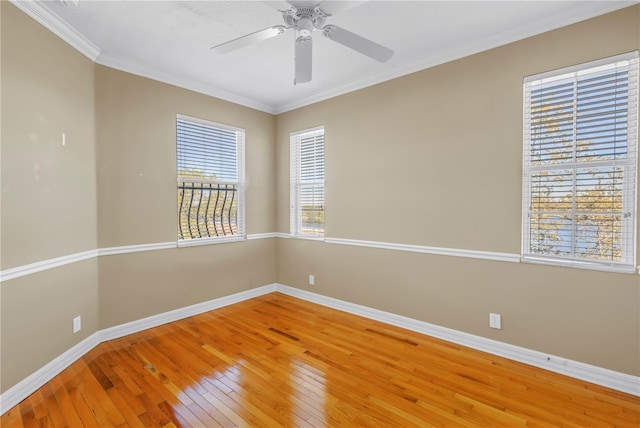 spare room with ceiling fan, light wood-type flooring, baseboards, and ornamental molding