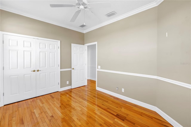 unfurnished bedroom with light wood-type flooring, baseboards, and crown molding