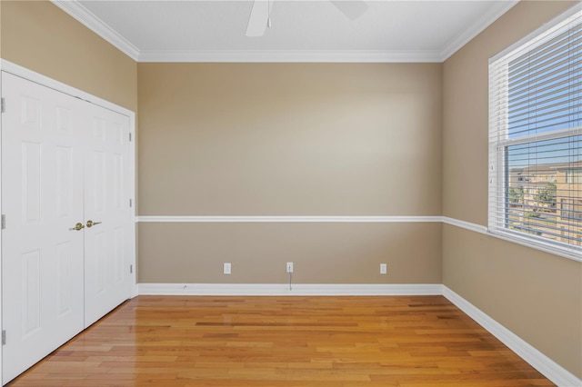 unfurnished bedroom with a closet, baseboards, light wood finished floors, and ornamental molding