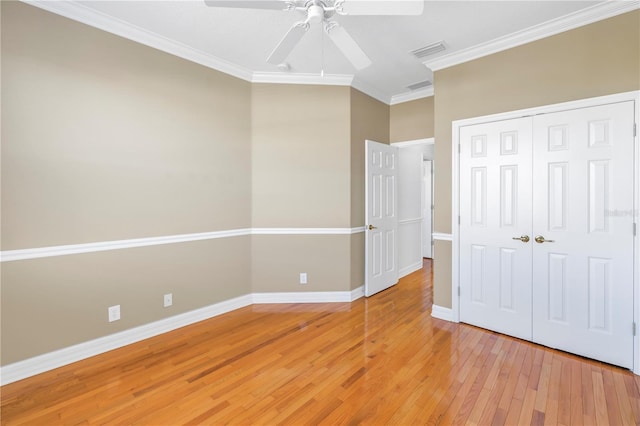 unfurnished bedroom with visible vents, crown molding, baseboards, light wood-style flooring, and a closet