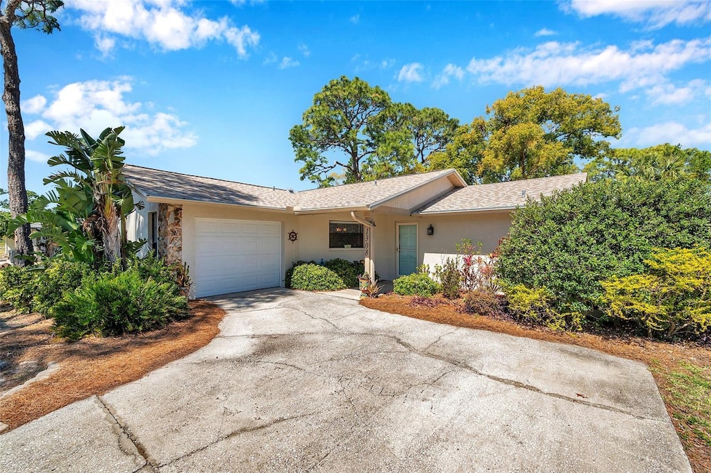 ranch-style house with an attached garage, driveway, and stucco siding