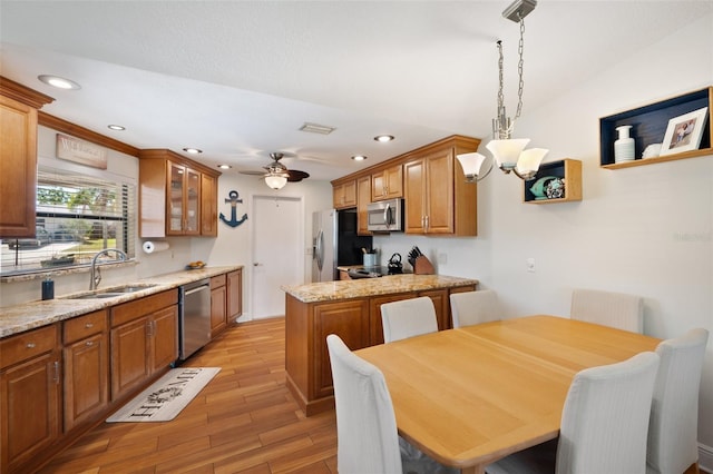 kitchen featuring a sink, brown cabinets, appliances with stainless steel finishes, and light wood finished floors