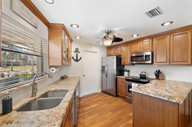 kitchen with visible vents, brown cabinets, a sink, stainless steel appliances, and ceiling fan