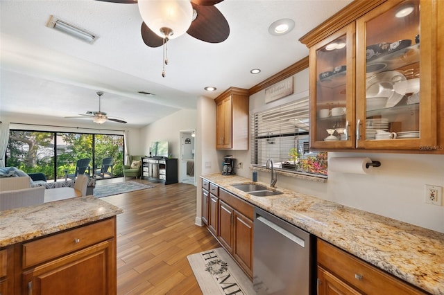 kitchen with a ceiling fan, light wood finished floors, a sink, dishwasher, and open floor plan