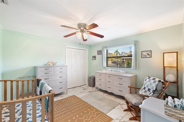 bedroom featuring a closet, marble finish floor, a ceiling fan, and visible vents