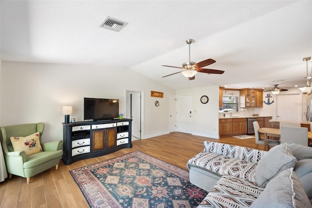 living room featuring baseboards, visible vents, lofted ceiling, ceiling fan, and light wood-type flooring