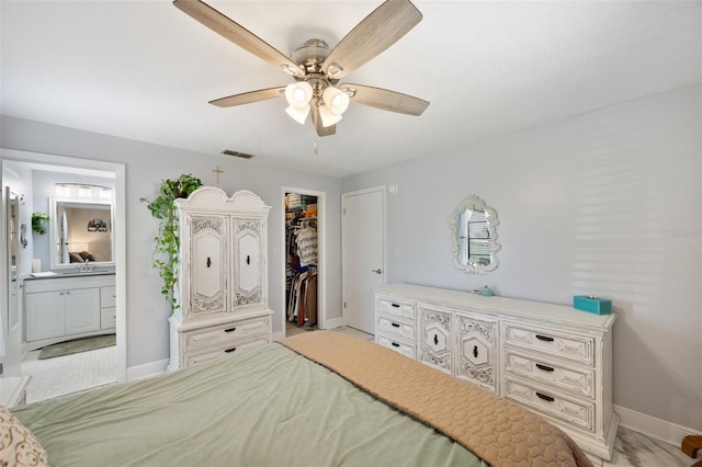 bedroom with a spacious closet, visible vents, connected bathroom, baseboards, and a closet