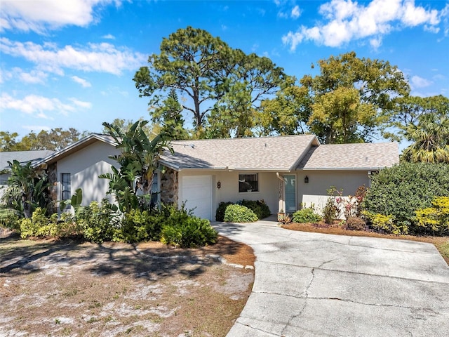 ranch-style house with stucco siding, driveway, an attached garage, and a shingled roof