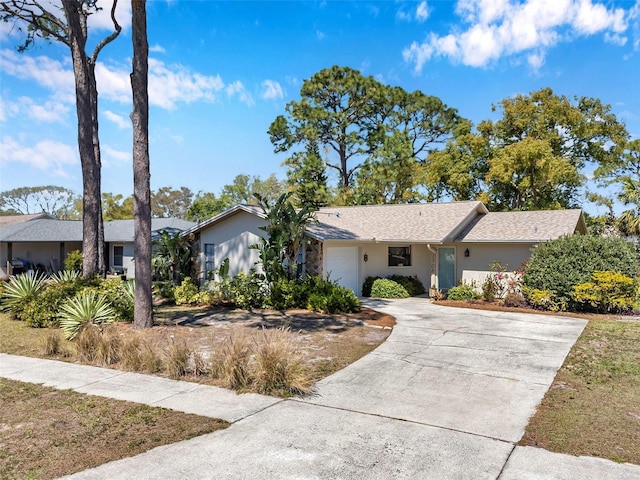 ranch-style house with stucco siding, an attached garage, and concrete driveway