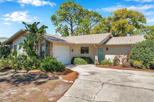 ranch-style home featuring stucco siding, an attached garage, and driveway