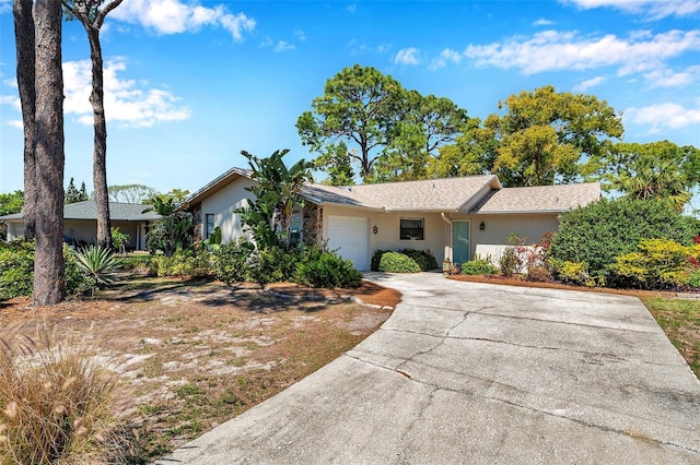 ranch-style house featuring stucco siding, driveway, and a garage