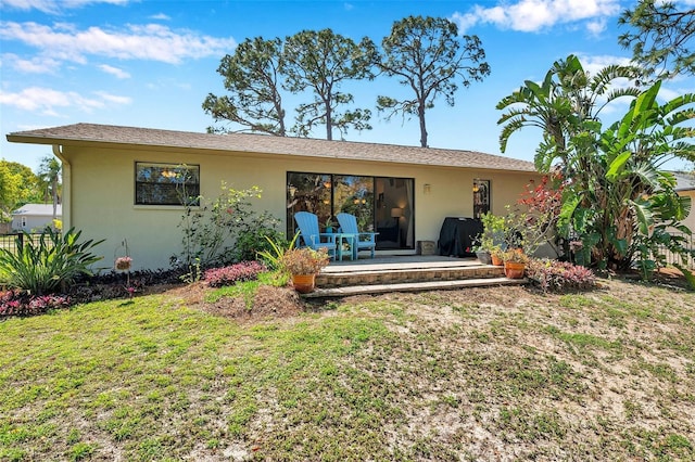 back of house with a patio, a yard, and stucco siding