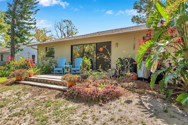 view of front of home with stucco siding and a patio area