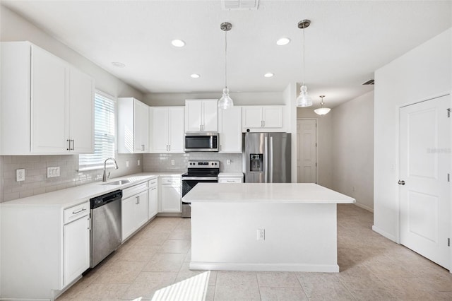 kitchen featuring a sink, stainless steel appliances, white cabinetry, tasteful backsplash, and a center island