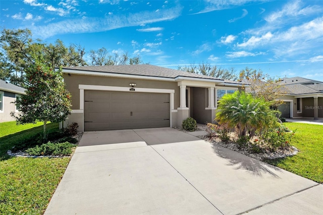 ranch-style house featuring stucco siding, a front lawn, concrete driveway, and a garage