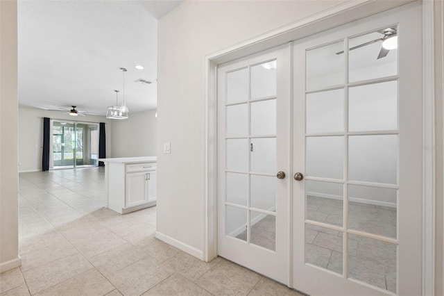 corridor featuring light tile patterned floors, baseboards, and visible vents