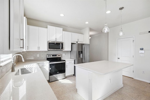 kitchen featuring decorative backsplash, white cabinetry, appliances with stainless steel finishes, and a sink