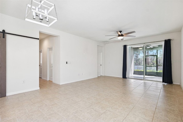 empty room with light tile patterned floors, a barn door, baseboards, and ceiling fan