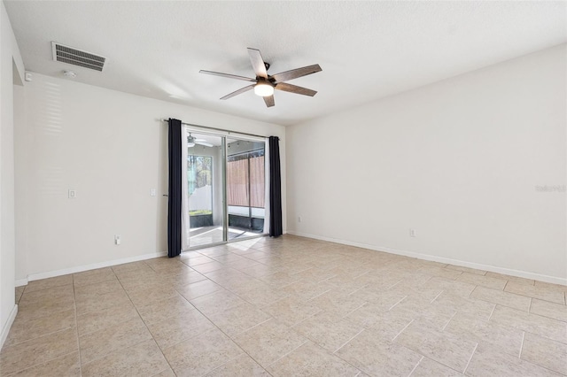 empty room featuring light tile patterned floors, visible vents, baseboards, and ceiling fan