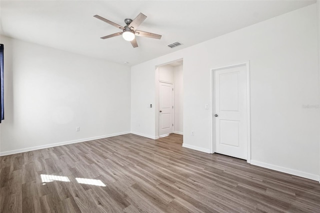 empty room featuring visible vents, baseboards, ceiling fan, and wood finished floors