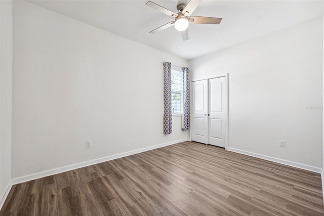 spare room featuring baseboards, a ceiling fan, and wood finished floors