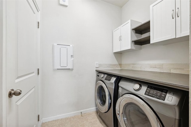 washroom featuring light tile patterned floors, baseboards, cabinet space, and washing machine and dryer