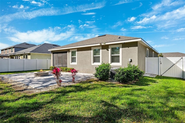 back of house featuring stucco siding, a gate, a patio area, and a fire pit