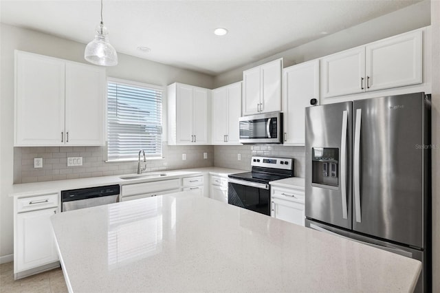 13001 Satin Lily Dr, Riverview, FL 33579 - kitchen with tasteful backsplash, white cabinetry, light stone countertops, appliances with stainless steel finishes, and a sink