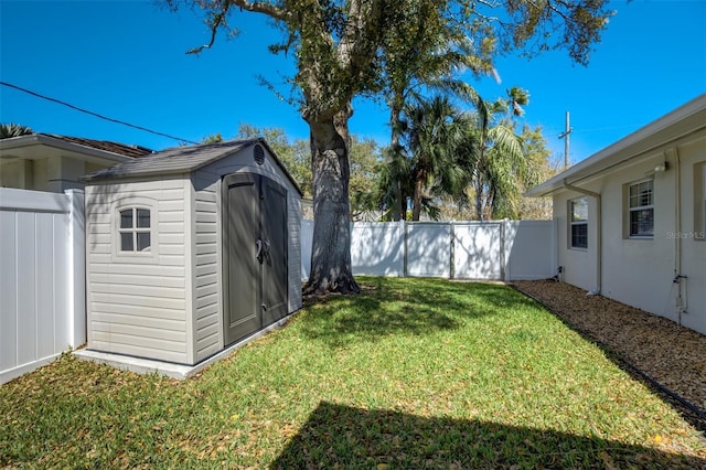 view of yard with an outbuilding, a storage unit, and a fenced backyard